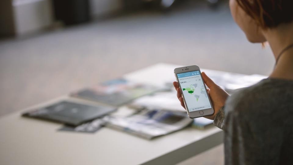 Mujer consulta información en su teléfono móvil